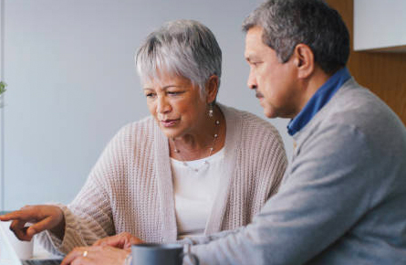 Senior woman and man figuring something out on the computer