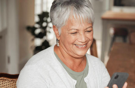 Senior woman smiling at her cell phone