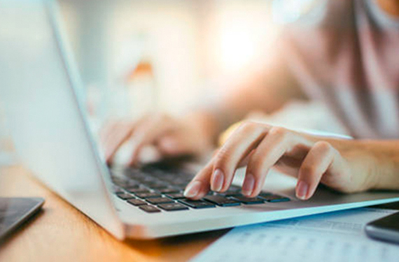 Focus on hands typing on a laptop